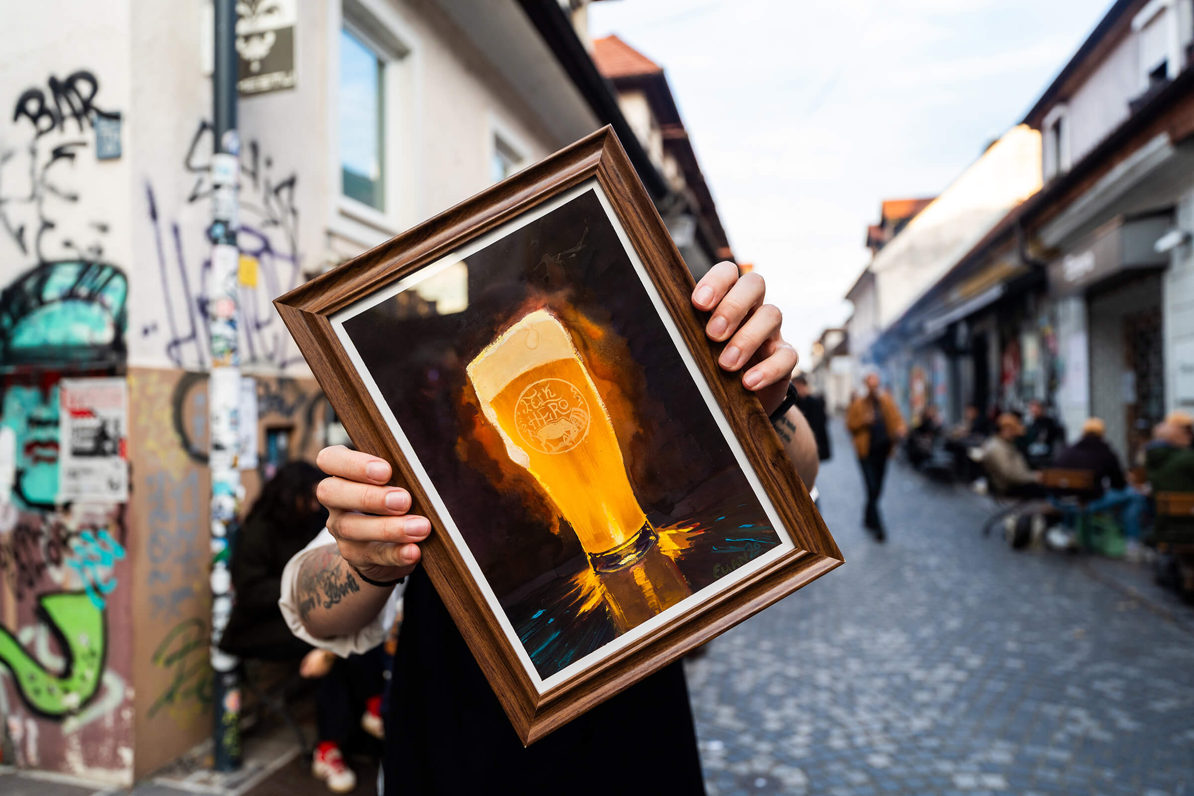 Framed painting of a glowing beer glass held up in the street outside :Projekt